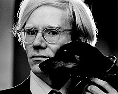 A black and white photo of Andy Warhol with a dog