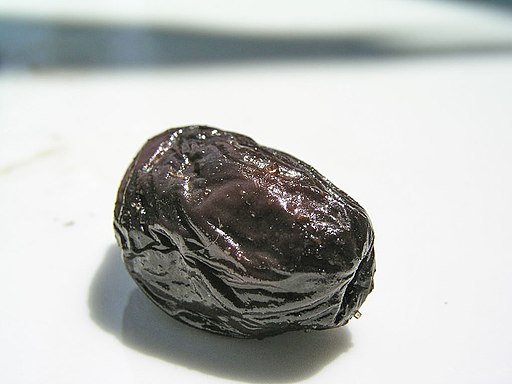 Black olive on a white surface