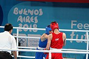 Deutsch: Boxen bei den Olympischen Jugendspielen 2018 Tag 12, 18. Oktober 2018 - Kampf um Bronze im Leichten Weltergewicht Jungen – Hassan Azim (Großbritannien, rot) schlägt Mohammed Boulaouja (Marokko, blau) RSC; Ringrichter ist Wulfren Olivares Peréz (Kolumbien). English: Boxing at the 2018 Summer Youth Olympics on 18 October 2018 – Bronze Medail Match Light Welterweight Boys - Hassan Azim (Great Britain, red) beats Mohammed Boulaouja (Morocco, blue) RSC; Referee is Wulfren Olivares Peréz (Columbia). Español: Boxeo en los Juegos Olímpicos Juveniles de Verano de 2018 en 18 de octubre de 2018 - Medalla de bronce de los hombres ligeros de peso welter: Hassan Azim (Gran Bretaña, rojo) vence a Mohammed Boulaouja (Marruecos, azul) RSC; El árbitro es Wulfren Olivares Peréz (Colombia).