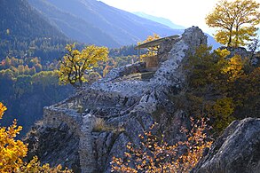 Ruins of walls. In the foreground, a wall square is partially destroyed on two sides.