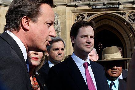 2009 photograph of UK Leader of the Opposition and future Prime Minister David Cameron (left), Lib Dem spokesman and future Secretary of State for Energy and Climate Change Chris Huhne (centre left) and Lib Dem leader and future Deputy Prime Minister Nick Clegg (centre right), all of whom had attended English public schools.
