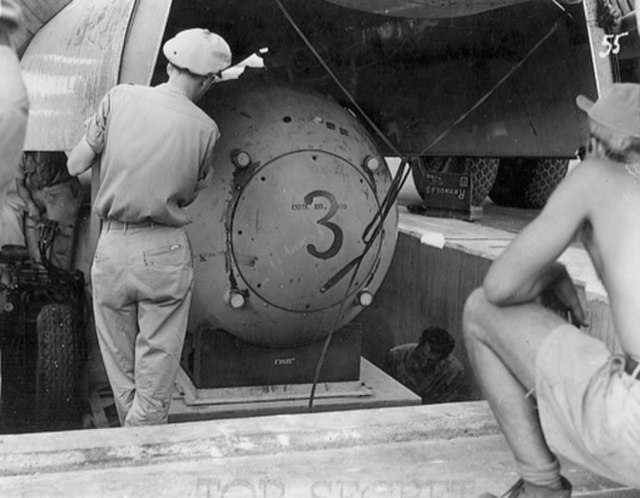 Fat Man test unit being raised from the pit into the bomb bay of a B-29 for bombing practice during the weeks before the attack on Nagasaki