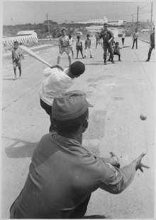 American G.I.s playing baseball with Dominican kid while the DOMREP is being discussed in the UN. G.I.'s playing baseball with Dominican kids. Santo Domingo, May 5., 1965 - NARA - 541975.tif