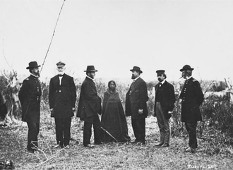 Indian Peace Commissioners and an unidentified Indigenous woman, from left to right, Terry, Harney, Sherman, Taylor, Tappan, and Augur Indian Peace Commission members with unidentified woman.png