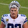 Headshot of Jason Witten on a football field in uniform with his helmet resting on top of his head