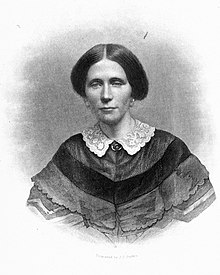 An engraved vignette portrait of a young white woman in 1859; she is wearing her hair center-parted and up off her neck; a white lace collar over a dark knitted shawl.