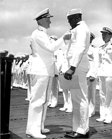 Admiral Chester W. Nimitz pins Navy Cross on Doris Miller, at ceremony on board warship in Pearl Harbor, May 27, 1942 Nimitz and miller.jpg