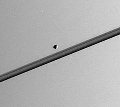 Пандора на снимке, сделанном Кассини — Гюйгенс в 2005 году; на заднем плане кольца Сатурна