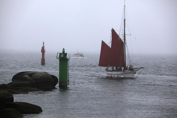The Ketch Popoff, approaching Concarneau harbour and passing between the sea mark buoys of the entrance, while an approaching trawler in the backgroun