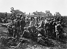 Men of the American 30th Division at rest with German prisoners following the capture of Bellicourt, 29 September 1918. In the background are British Mark V tanks (with 'cribs' for crossing trenches) of the 8th Battalion, Tank Corps, which was one of four battalions of the 5th Tank Brigade allotted to the 5th Australian Division and American Corps for the operation. The Hundred Days Offensive, August-november 1918 Q9365.jpg