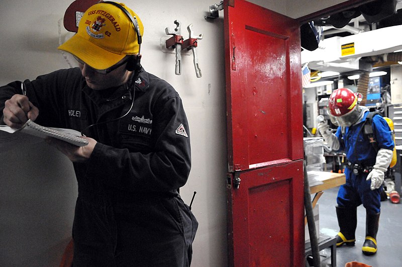 File:US Navy 110202-N-9818V-139 Damage Controlman 1st Class Branden Hudley evaluates Logistics Specialist 2nd Class Edgar Andres after boundaries are se.jpg