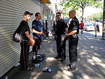 Officers of the Vancouver Police Department checking for stolen goods at a flea market Vancouver Police at the Hastings "Flea Market" for Stolen Goods.jpg