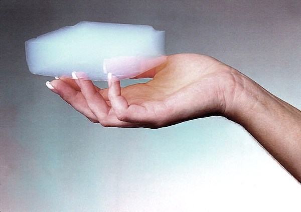 A block of silica aerogel in a hand.