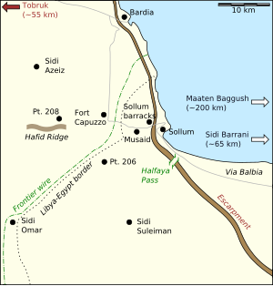 A large scale coloured map showing the Egyptian–Libyan border near the coast; dotted lines identify the border and frontier barbed wire fence while black dots represent important places and towns.