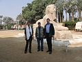 Three people stood in front of a statute of a sphinx