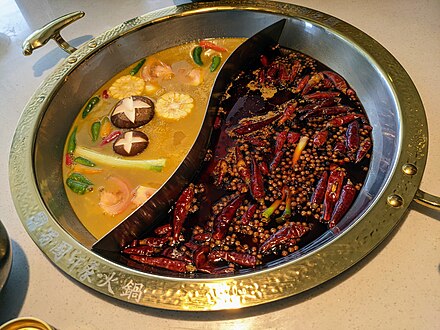 Chengdu-style double hotpot, with sour suancai pickled cabbage broth (left) and spicy mala broth (right(