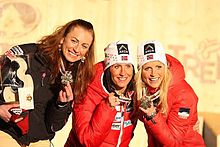 Trois skieuses, montrant aux photographes leurs médailles