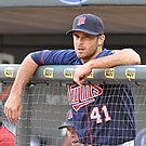 Ein Minnesota Twins-Spieler, der sich während eines Baseballspiels auf das Geländer des Unterstandes stützt.