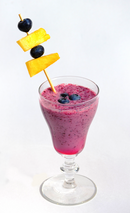 Blueberry smoothie topped with blueberries and pineapple pieces