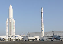 Sur le tarmac se côtoient des avions modernes et les maquettes des fusées Ariane 1 et Ariane 5.