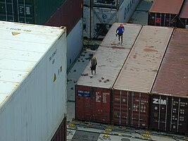 Dockworkers on the containers in the ship's hatch
