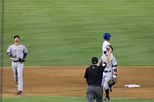 An umpire (in black shirt) indicating an infield fly--a verbal call is also made Infield fly.jpg