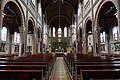 Interieur van de kerk van onder orgel naar koor gezien