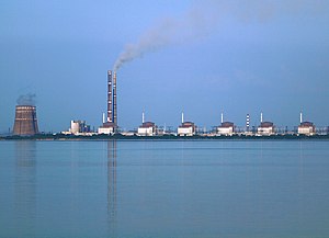Vue de la centrale nucléaire de Zaporijia depuis l'ouest avec les tranches 1 à 6 (de droite à gauche).  Les deux hautes cheminées appartiennent à la centrale thermique de Zaporijia