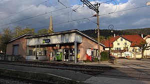 Station building with a ticket machine next to a railway crossing