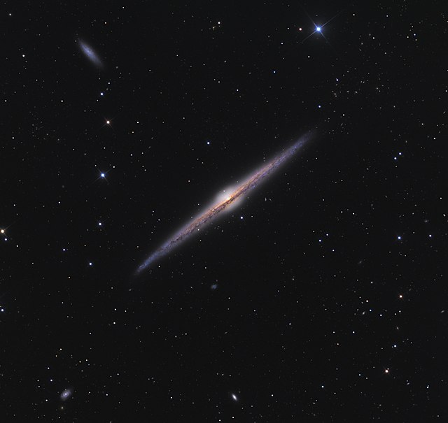 المجرَّة الحلزونيَّة العملاقة NGC 4565 التي تبعد عن الأرض مسافة تتراوح بين 30 و50 مليون سنة ضوئيَّة، وهي مثال بارز لِمجرَّةٍ حلزونيَّةٍ من طرفها