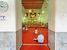Buddhist gatherers inside Wat Mahathat Yuwaratrangsarit, Bangkok are regulated to keep distance from each others Physical distancing during COVID-19 in Thai temple 01.jpg