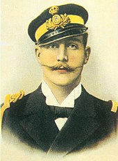 Photographie ancienne en couleurs : homme moustachu avec une casquette et uniforme.