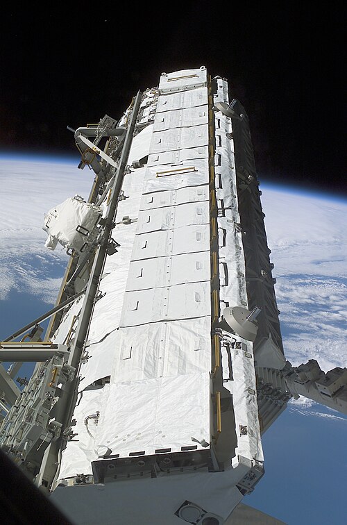Canadarm2 takes the S1 truss out of the payload bay of Atlantis, prior to its installation on the ISS
