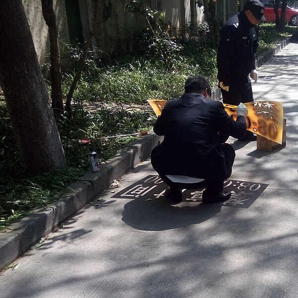 File:Spray painting numbers on Chinese street Hangzhou.jpg