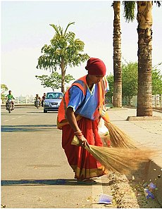Woman sweeping the road