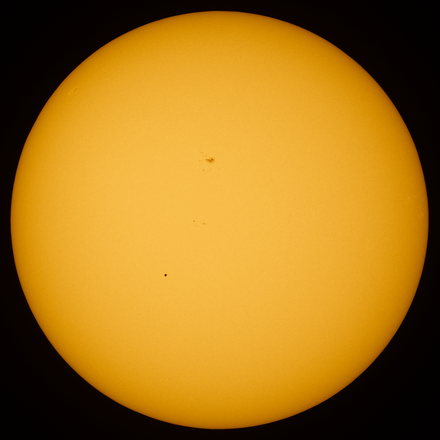 Transit of Mercury. Mercury is visible as a black dot below and to the left of center. The dark area above the center of the solar disk is a sunspot.