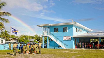 Students at the Majuro Cooperative School raise the Republic of the Marshall Islands flag at a ceremony during a Pacific Partnership 2009 community service project