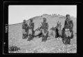 A tribal lunch at cavalry post at Tel-el-Meleiha, 20 miles North of Beersheba, Jan. 18, 1940. Gen(eral) view with men & camels of the camel corps in the foreground LOC matpc.19969.tif