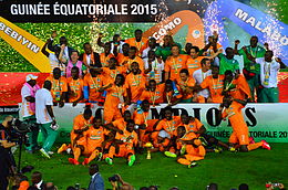 Tioté, standing next to Serge Aurier, celebrates winning the 2015 Africa Cup of Nations with the Ivory Coast national team