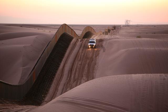 U.S. Border Patrol at Algodones Sand Dunes, California. The fence on the U.S.–Mexican border is a special construction of narrow, 4.6 m (15 ft) tall e