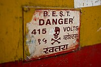 Skull and crossbones on a sign warning of high voltage in Mumbai, India
