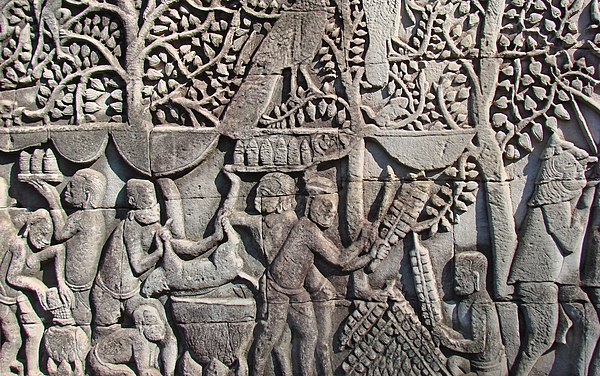 A bas-relief of the 12th/13th century Bayon temple depicting a Khmer outdoor kitchen cooks grilling sang vak and cooking rice and a wild boar and serv