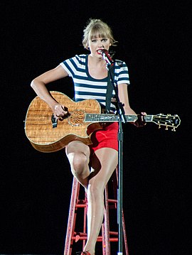 Taylor Swift performing on a guitar