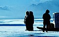 Inuit on the sea ice in front of foggy Bylot Island