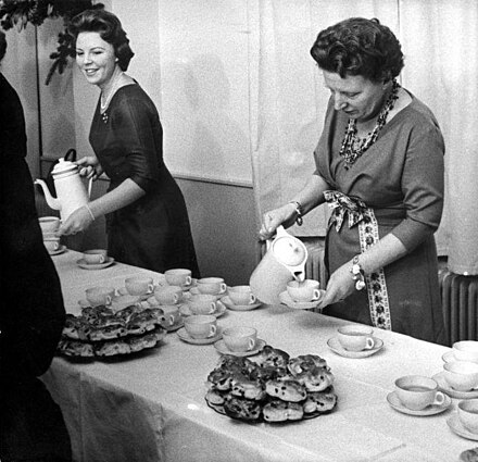 Queen Juliana and Princess Beatrix serving cocoa and buns to their staff on Christmas 1960