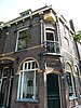 Winkelwoonhuis met bovenwoning, hoekpand, onderdeel van het blokje met een winkel en woningen, deels beneden- en bovenwoningen, in 1903 gebouwd door meester-metselaar en aannemer Mels Meyer, in een traditionalistische bouwtrant met invloeden van de Nieuwe Kunst. Het pand is van belang als onderdeel van het blokje Oosteinde 144 t/m 150 dat als blokje van algemeen belang is voor de gemeente Delft vanwege de architectuurhistorische en cultuurhistorische waarde.