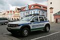 Čeština: Město Domažlice. Vozidlo městské policie zaparkované před radnicí na náměstí Míru. V pozadí kostel Narození Panny Marie, hotel Zlatá Včela v domě čp. 131 (modrý) a další domy na náměstí.