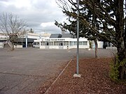 Fotografía en color de una escuela cuyo nombre se indica en la fachada: colegio Georges-Brassens.