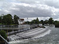The weir at Hambleden Lock on the River Thames at Hambleden, Buckinghamshire. A broad-crest weir, the public has right of way to cross the river using its walkway.
