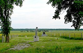 Commemorative statue entitled "Never Forget" / "Ne Jamais Oublier" / "Nikoli Ne Zabuti (Nikoly Ne Zabuty)", by John Boxtel; and damaged plaque at the cemetery of the Kapuskasing Internment Camp, Kapuskasing, northern Ontario Kapuskasing ON 3.JPG